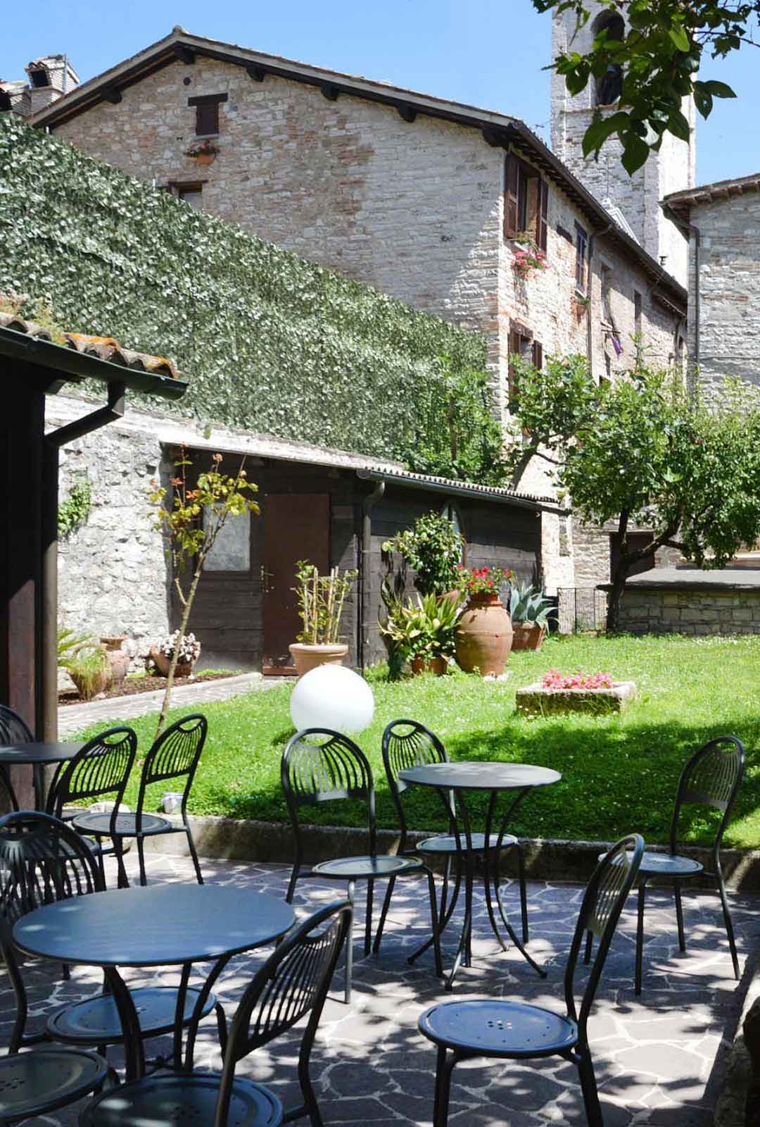 Tavolini e giardino della residenza di via piccardi in una giornata soleggiata